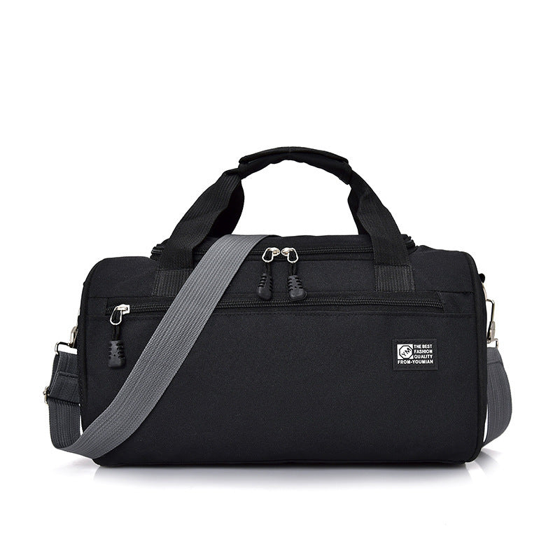 Black duffel bag with gray shoulder strap on a white background