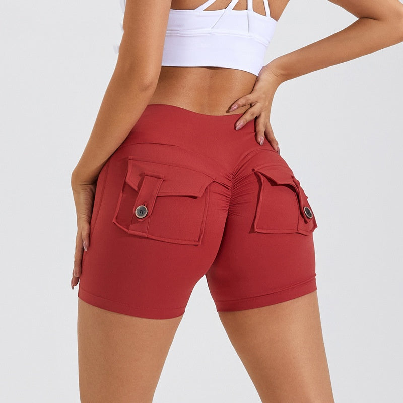 Red athletic shorts with pockets worn by a person on a white background