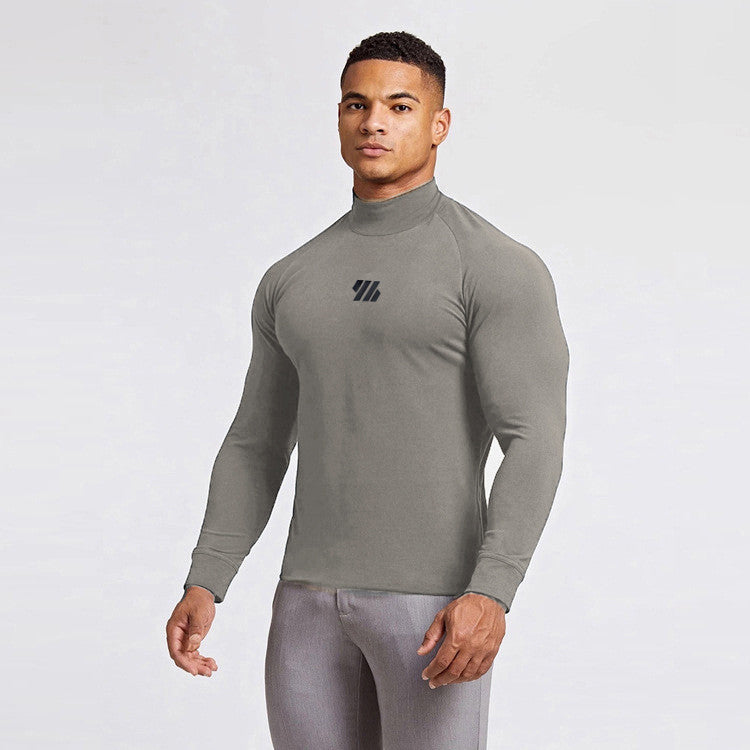 Man wearing a gray long-sleeve athletic shirt with a logo on a white background