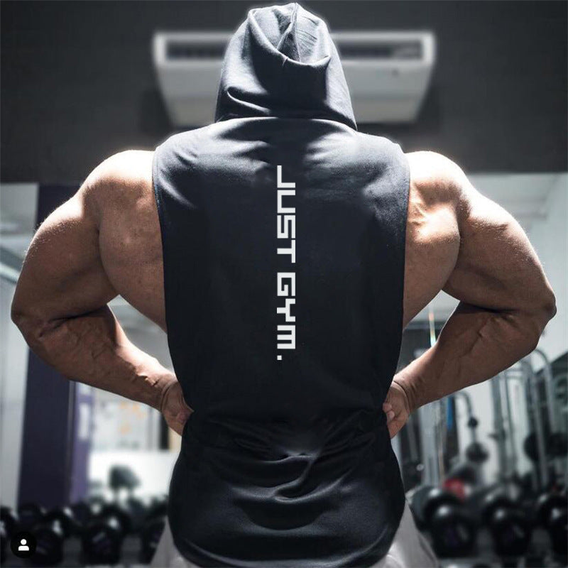 Person wearing a black sleeveless hoodie with 'JUST GYM.' text in a gym setting