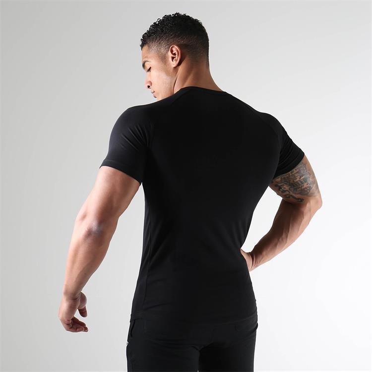 Man wearing a black t-shirt against a gray background