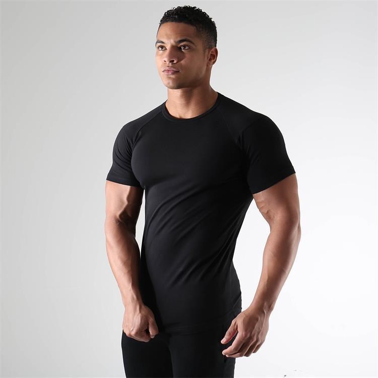 Man wearing a black t-shirt against a gray background