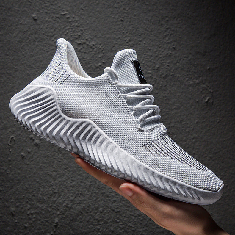 White sneaker held against a dark gray background