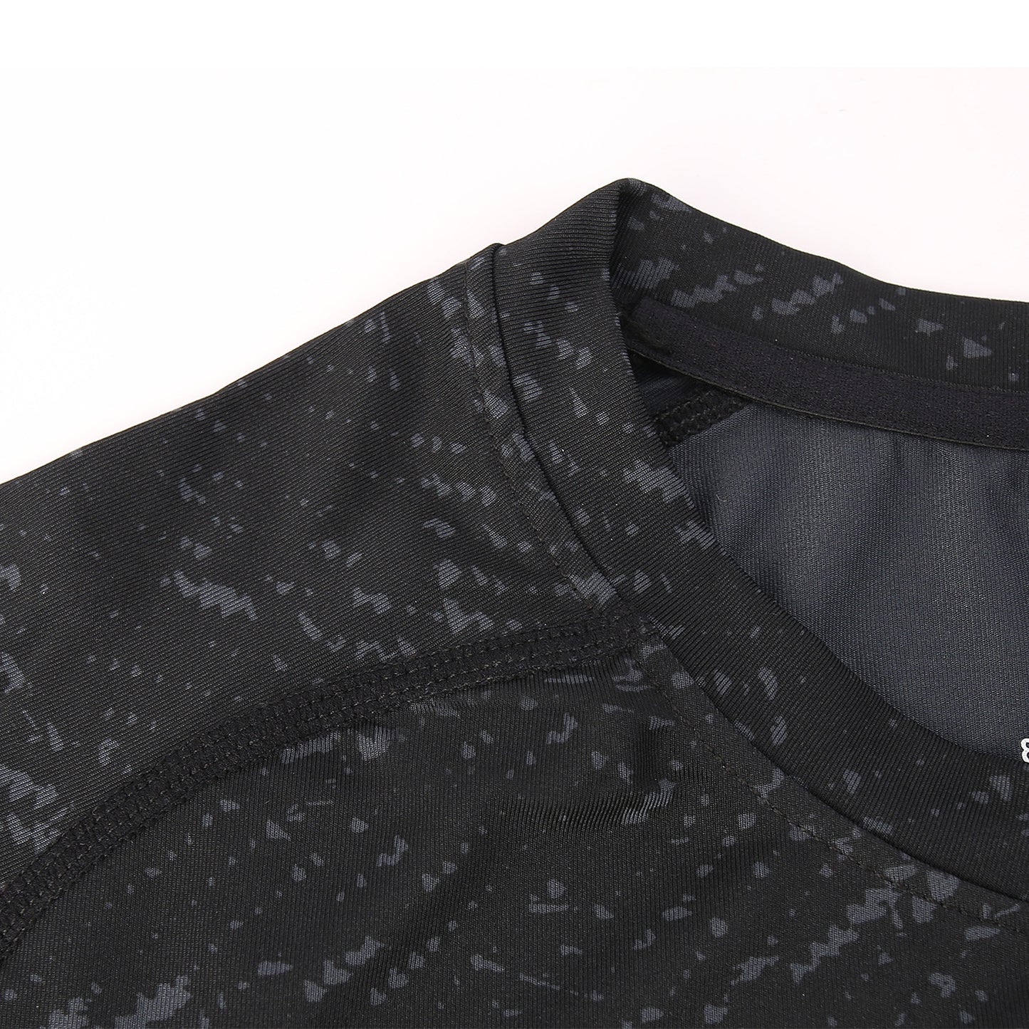 Close-up of a black athletic shirt with subtle pattern on a white background