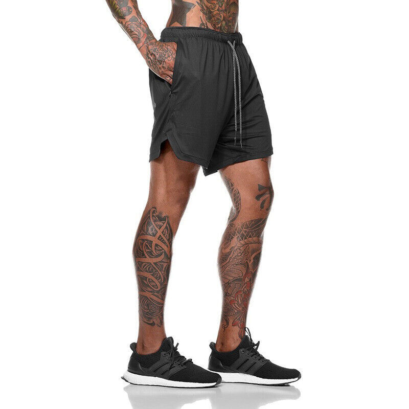 Person wearing black athletic shorts and black sneakers on a white background