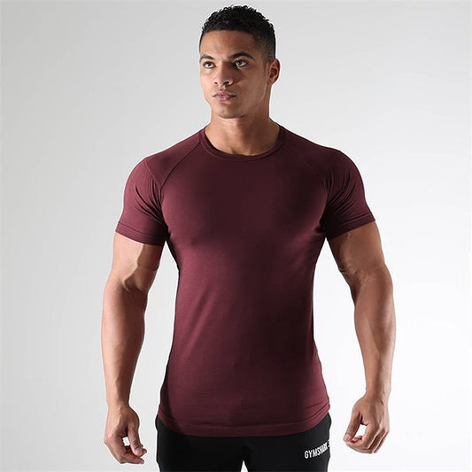 Man wearing a maroon athletic shirt on a gray background