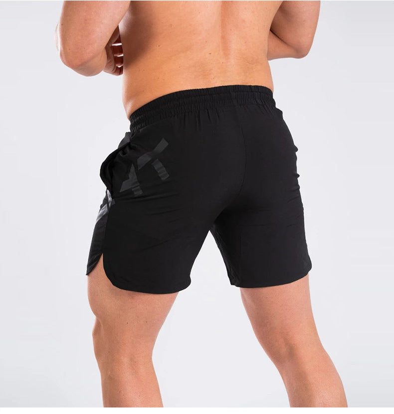 Person wearing black shorts with a logo on a white background