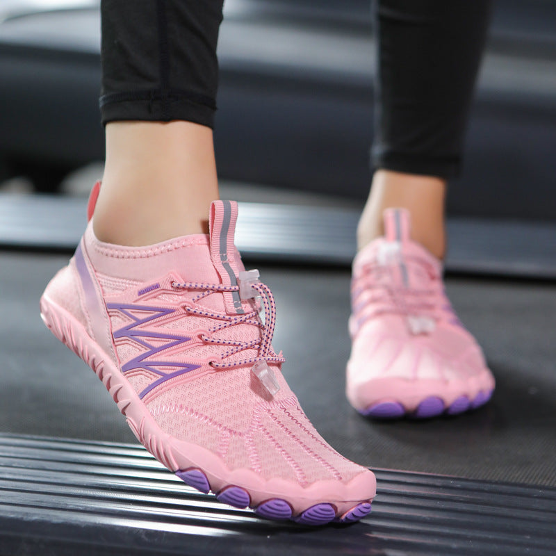 Pink and purple shoes worn on a black surface