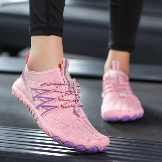 Pink and purple shoes worn on a black surface