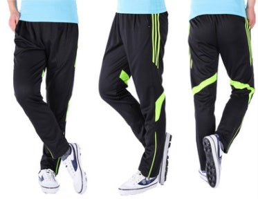 Black pants with green stripes worn by a person on a white background