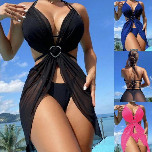 Black swimsuit with heart detail worn by a model against a scenic background.