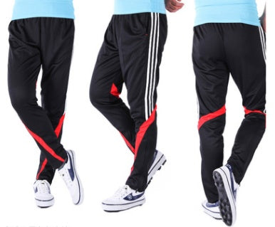 Black track pants with red accents and white stripes on a white background
