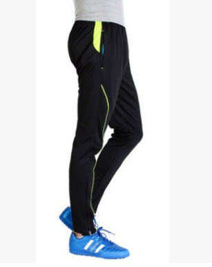 Black pants with a green stripe worn by a person on a white background
