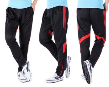 Black tracksuit pants with red accents worn by a person on a white background