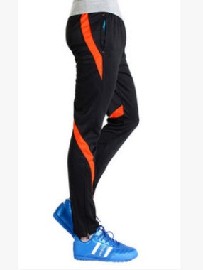 Black pants with orange stripes and blue sneakers on a white background
