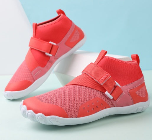 Red children's shoes with white soles on a light blue background