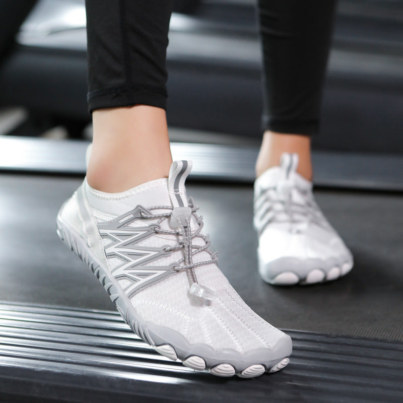 White athletic shoes with unique sole design on a treadmill.