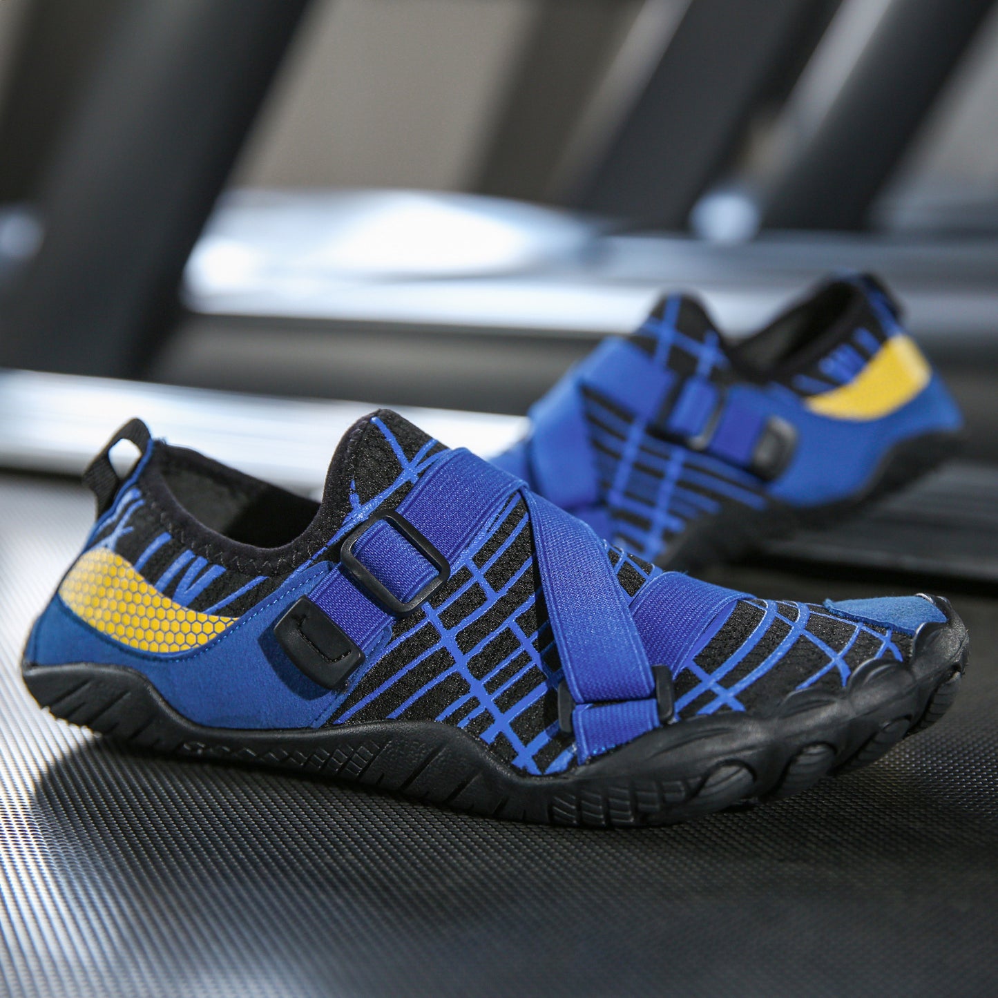 Blue and black water shoes with yellow accents on a metallic surface